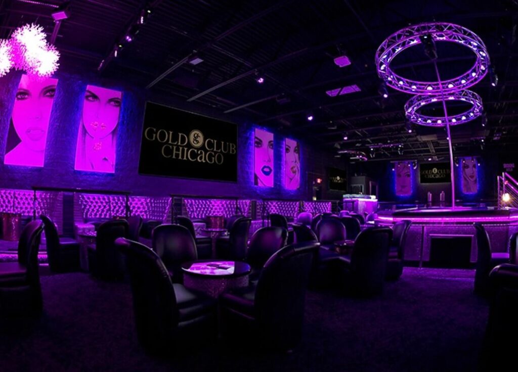 Elegant interior of The Gold Room Chicago strip club with vibrant purple lighting.