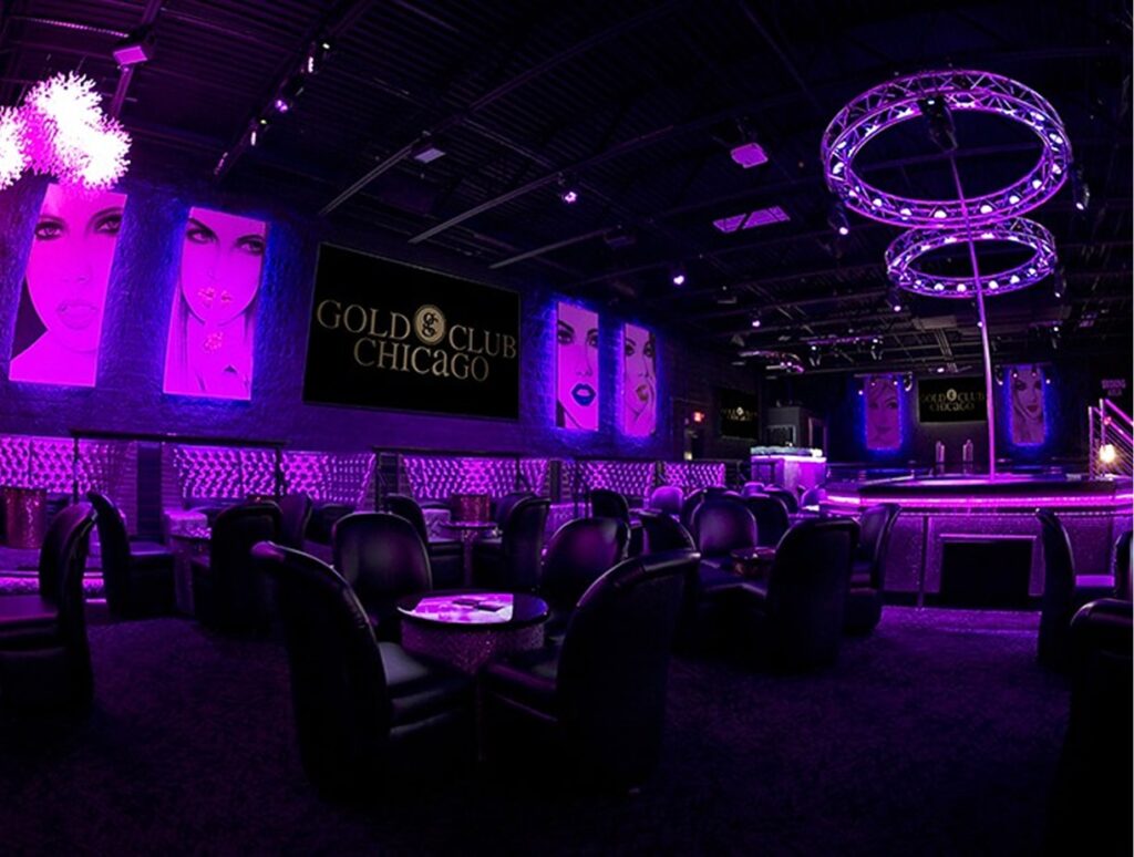 Interior view of The Gold Room Chicago strip club with vibrant purple lighting and modern decor.
