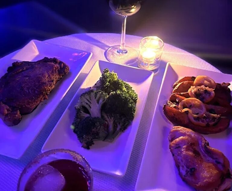 Delicious grilled steak with broccoli and shrimp, served with wine and candlelight ambiance at The G.