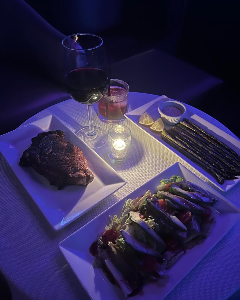 Elegant dinner setup with wine, steak, and salad at The Gold Room Chicago.